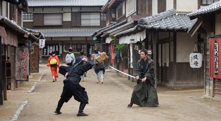 Samurai y ninja peleando en antiguas calles japonesas